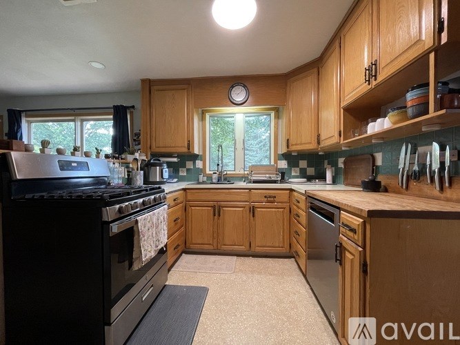 A kitchen with wooden cabinets and a black stove top oven.