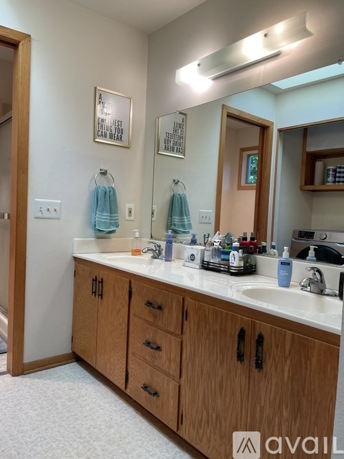 A bathroom with a sink, mirror, and cabinets.