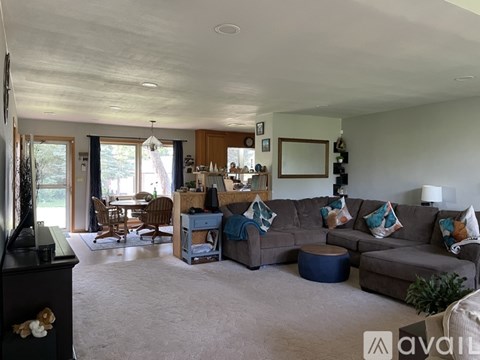 A living room with a grey couch and a wooden cabinet.