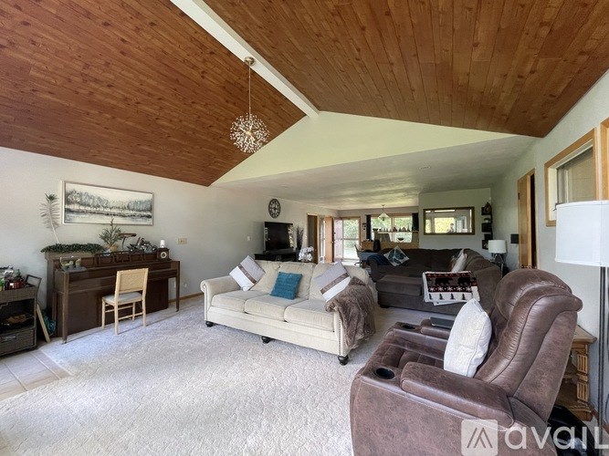A living room with a brown leather chair and a white couch.