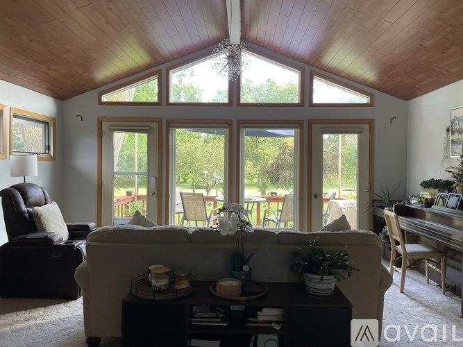 A living room with a couch, chair, and a table with a plant on it.