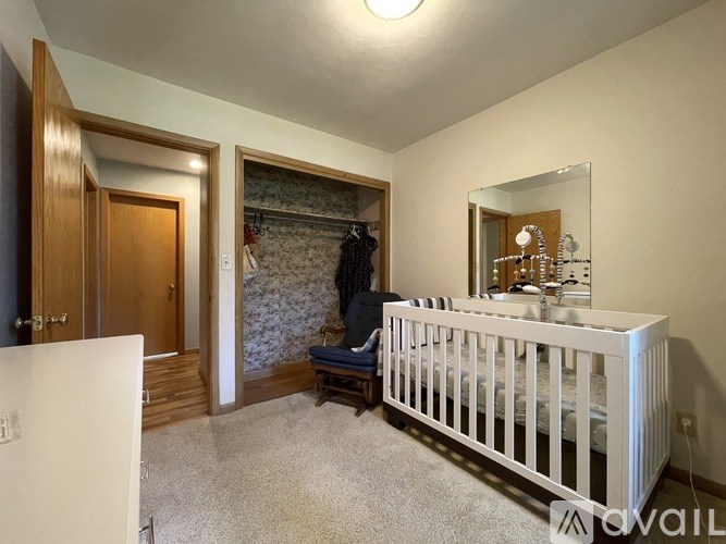 A baby's room with a white crib and a mirror on the wall.