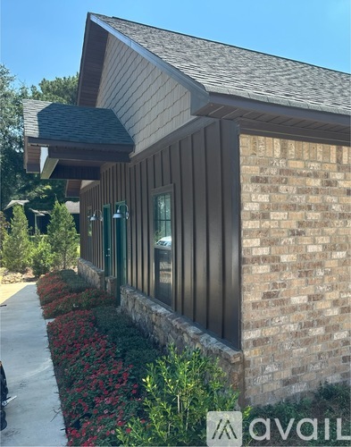 A house with a brown wooden exterior and a brick wall.