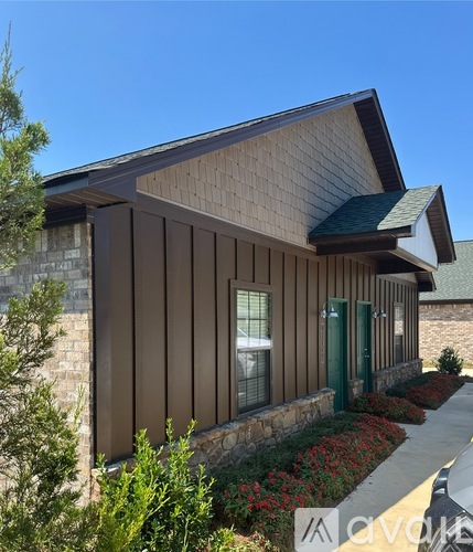 A house with a brown siding and a green door.