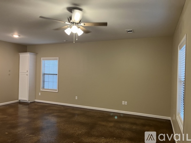 A room with a ceiling fan and a cabinet.
