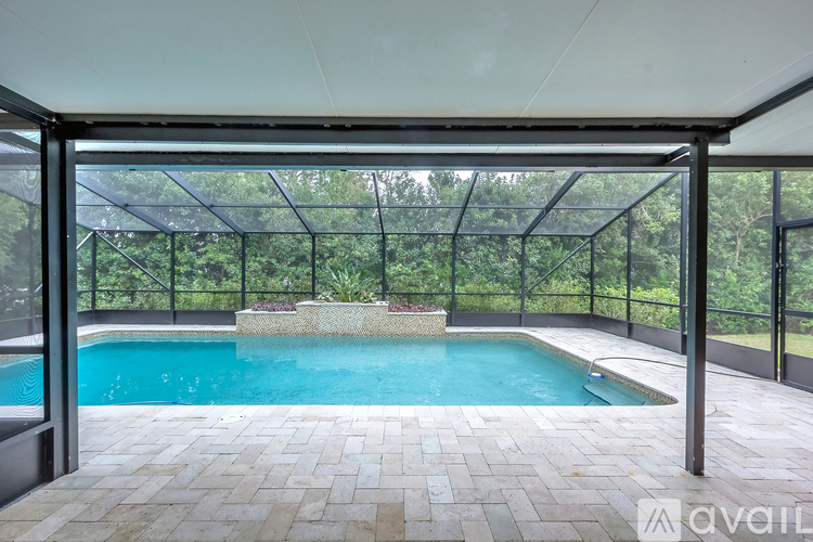 A pool enclosed by a glass wall and a tiled floor.