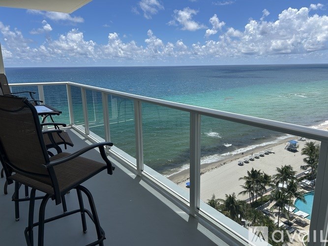 A chair is on a balcony overlooking the ocean.