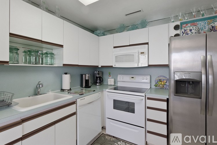 A kitchen with white cabinets and a stainless steel refrigerator.