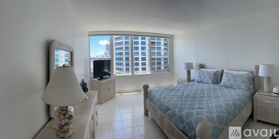 A bedroom with a large bed and a television.