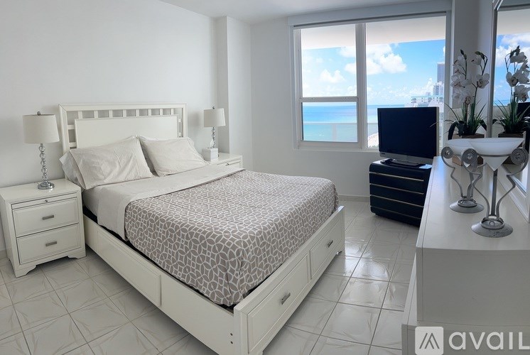 A bedroom with a large bed and a television on a cabinet.