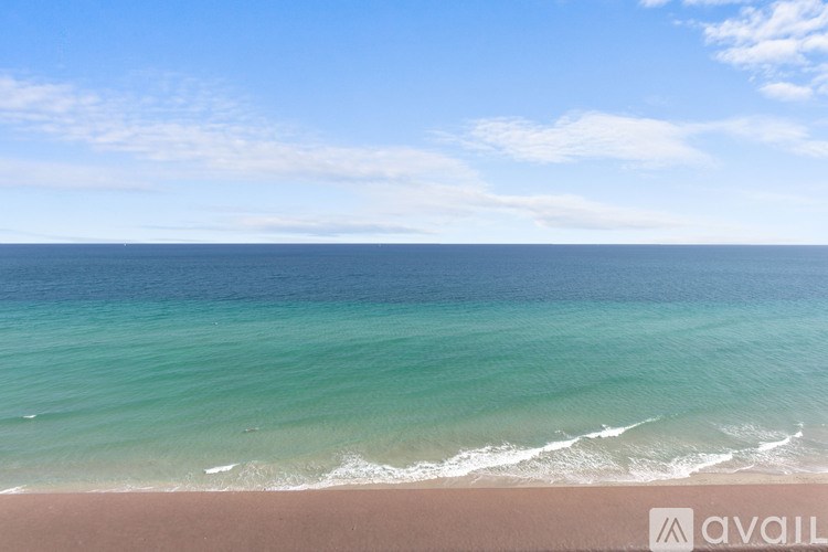 A beach with clear blue water and white waves.