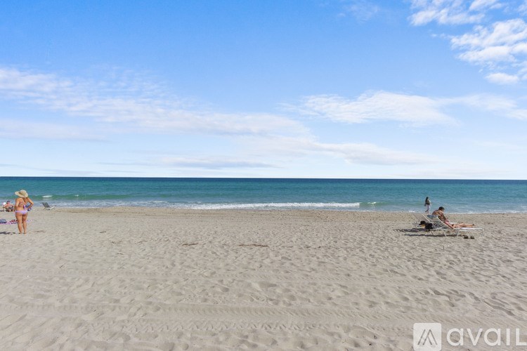 A beach scene with people sunbathing and walking.