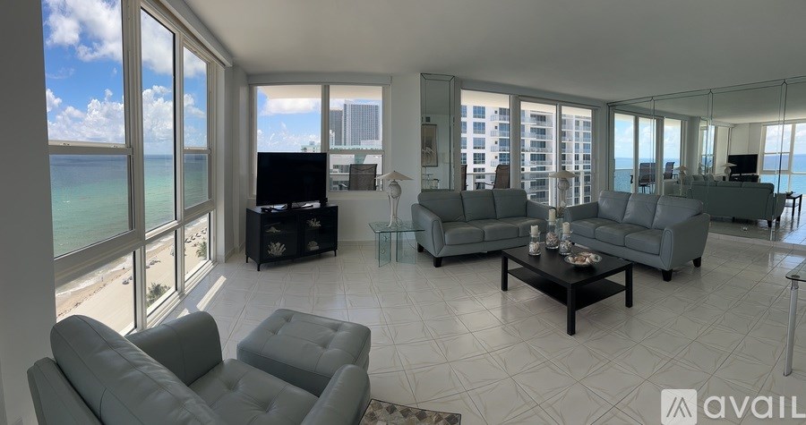 A living room with a large window overlooking the beach.