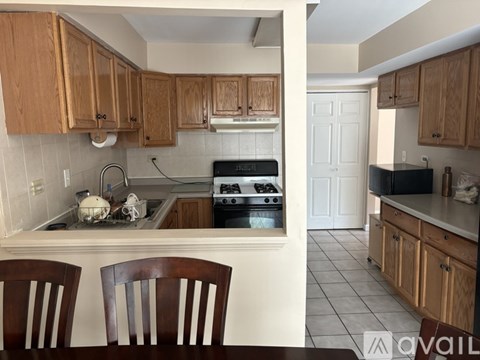 A kitchen with wooden cabinets and a black stove top oven.
