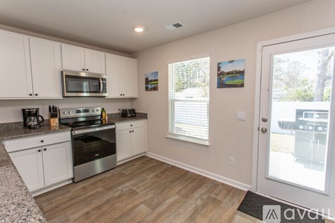 A kitchen with white cabinets and a granite countertop.