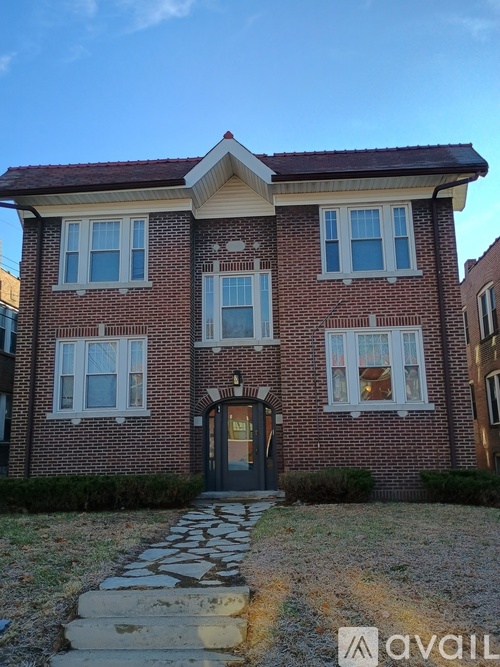 A brick house with a stone pathway leading to the front door.
