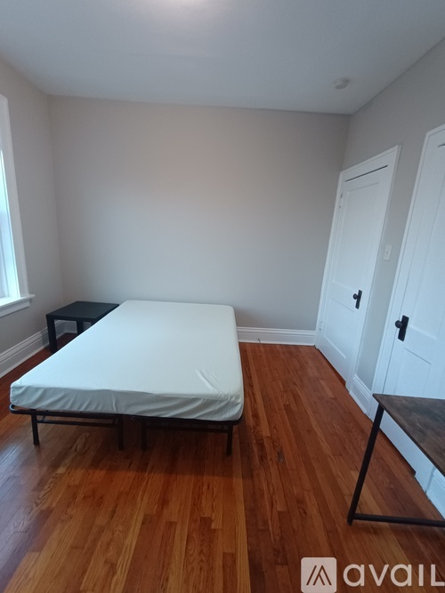 A bedroom with a bed, nightstand, and chair.