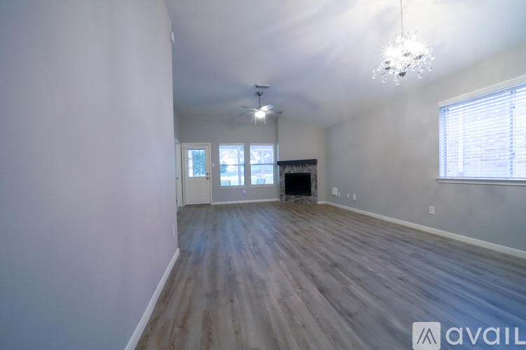 A room with wooden flooring and a chandelier.