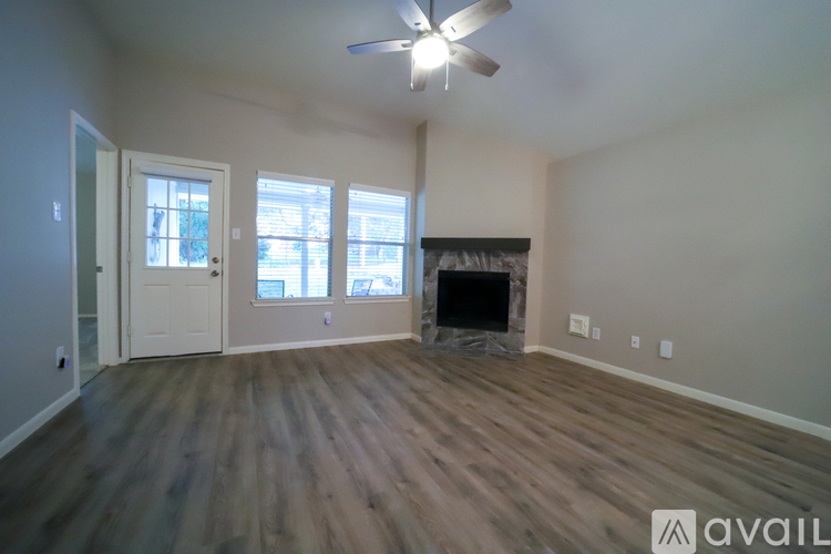 A room with a fireplace and a ceiling fan.