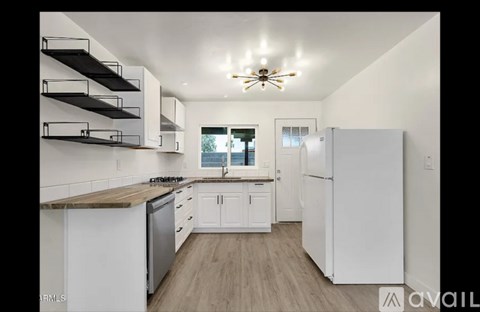 A kitchen with white cabinets and a wooden countertop.