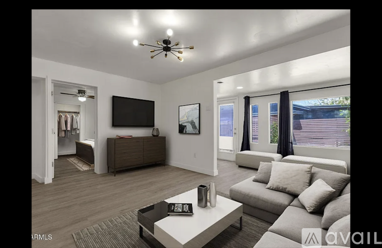 A living room with a couch, a coffee table, and a television.