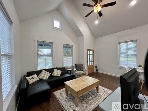 A living room with a black couch and a wooden coffee table.