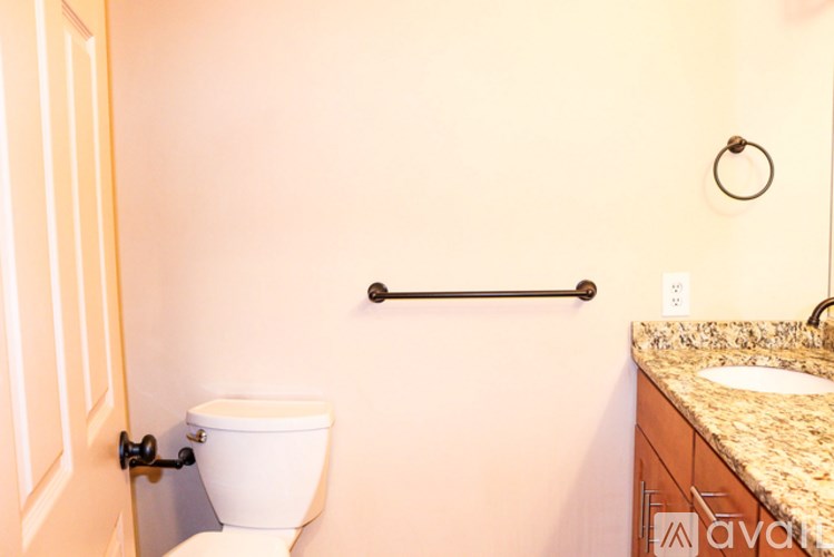 A bathroom with a toilet, a grab bar, and a sink.