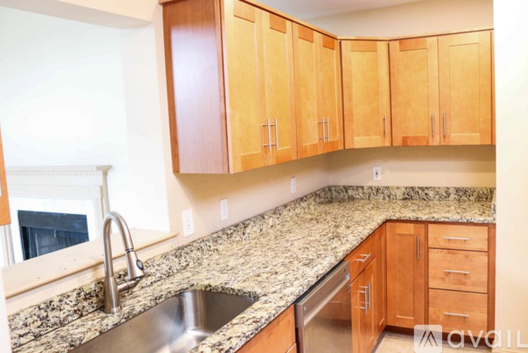 A kitchen with wooden cabinets and granite countertops.
