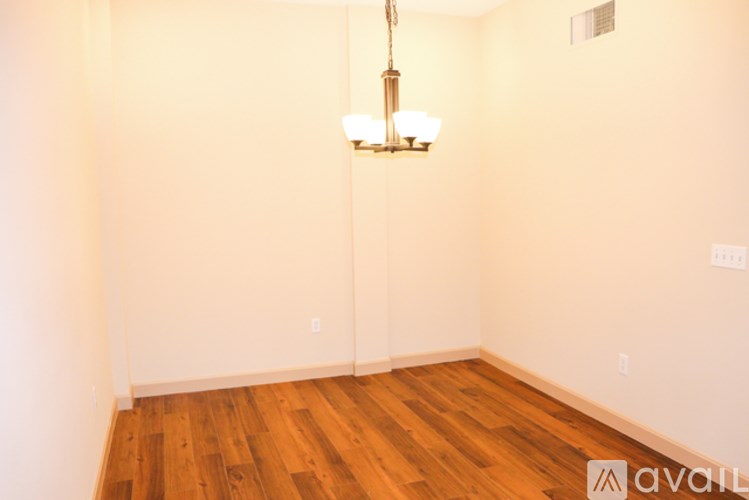 A room with wooden floors and a chandelier hanging from the ceiling.