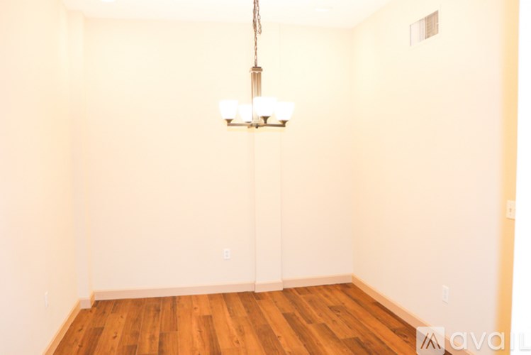A room with wooden floors and a chandelier hanging from the ceiling.
