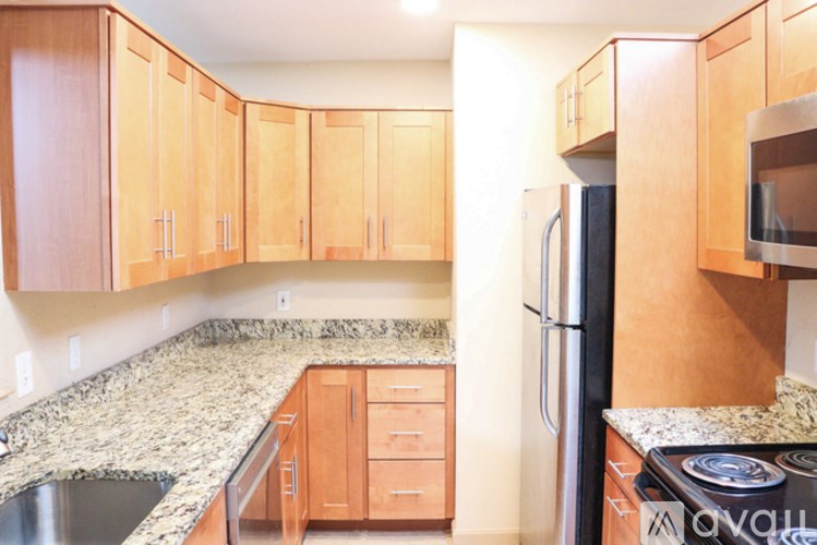 A kitchen with wooden cabinets and granite countertops.