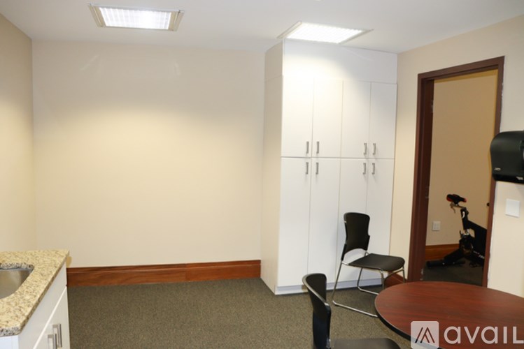 A room with a table, chairs and a cabinet.