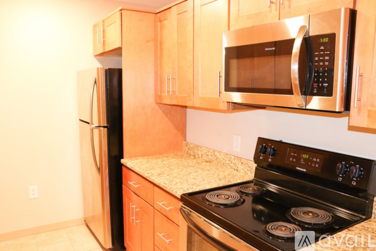 A kitchen with a stove, microwave, and refrigerator.