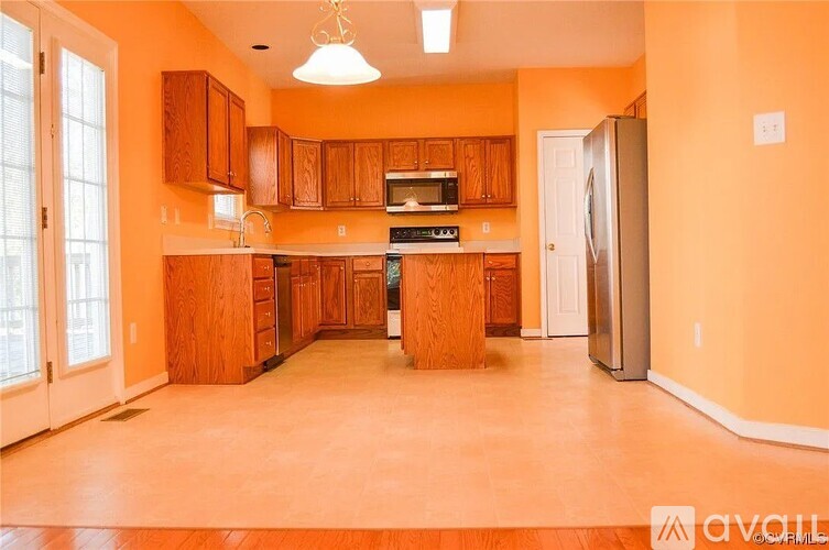 A kitchen with wooden cabinets and a refrigerator.
