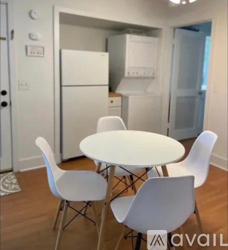 A kitchen with a table and chairs.