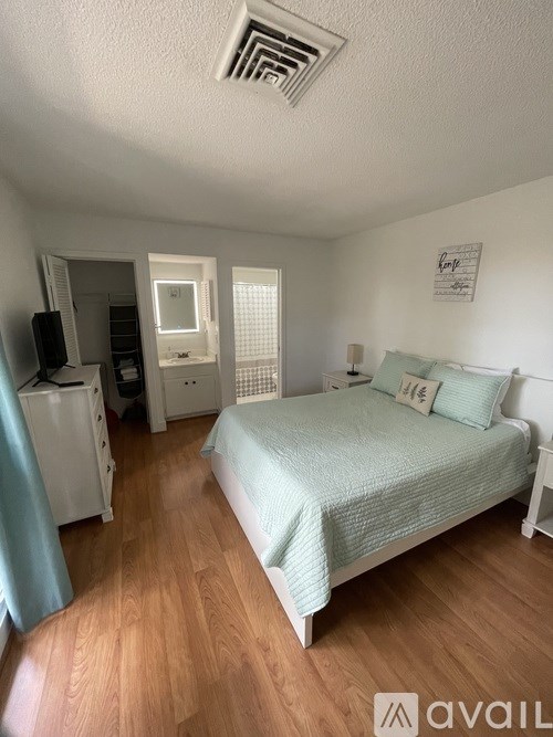 A bedroom with a bed, dresser, and mirror.