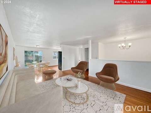 A living room with a white couch, a coffee table, and a large painting on the wall.