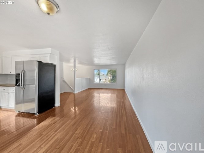 A kitchen with a refrigerator, microwave, and oven is available for rent.