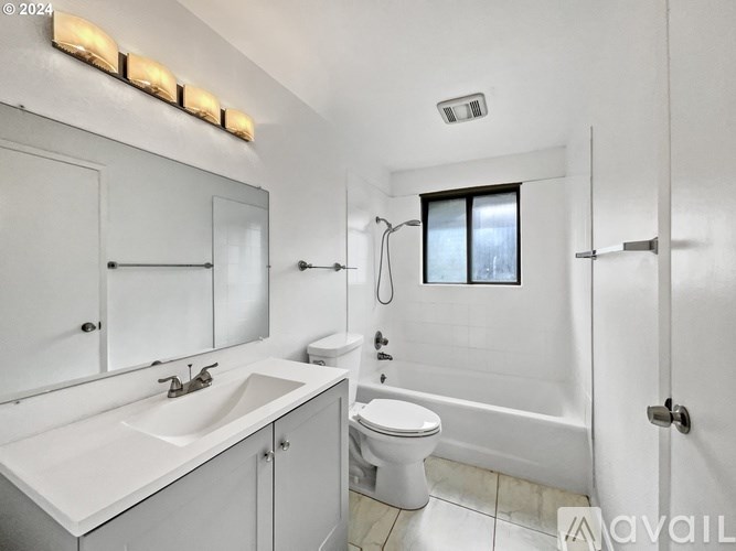 A white bathroom with a sink, toilet, and bathtub.