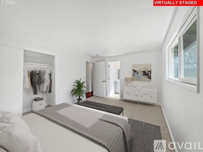 A bedroom with a bed, a wardrobe, and a dresser.