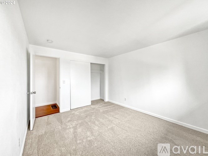 A room with a carpeted floor and a door on the left side.