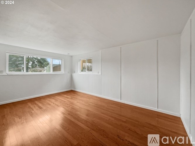 Empty room with wooden flooring and white walls.
