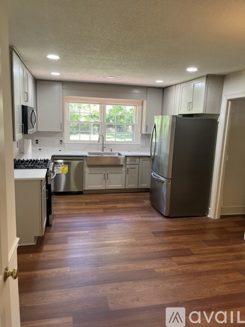 A kitchen with wooden floors and stainless steel appliances.
