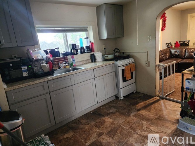A kitchen with a white counter top and a tiled floor.