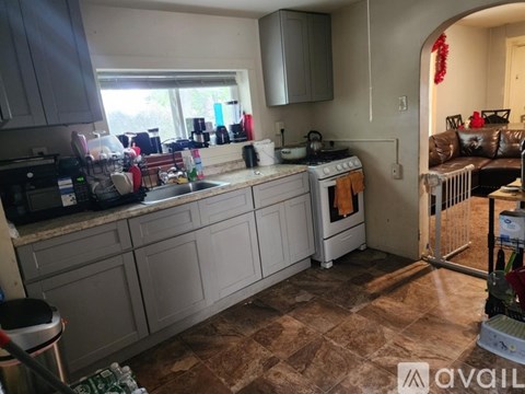 A kitchen with a white counter top and a tiled floor.