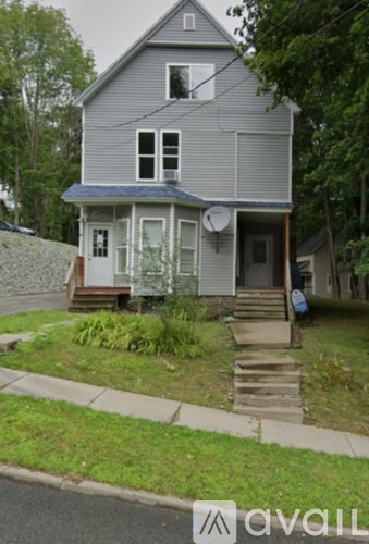 A grey house with a white door and windows.