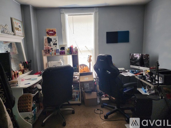 A room with two chairs, a desk, and a computer setup.