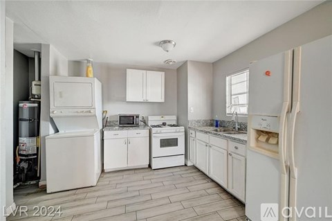 A kitchen with white appliances and cabinets.