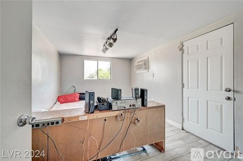 A room with a wooden cabinet and various electronic devices on top of it.