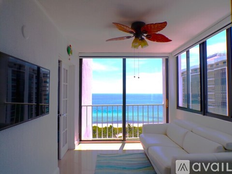 A living room with a white couch and a ceiling fan.